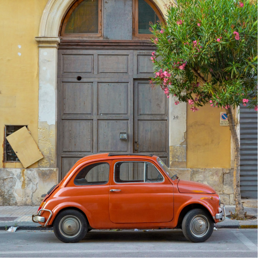 Fiat 500 portocaliu pe o stradă din Sicilia